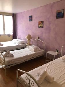 two beds in a room with pink walls at Hotel François 1Er in Manosque