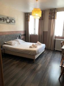 una camera da letto con un letto e due pantofole sopra di Hotel François 1Er a Manosque