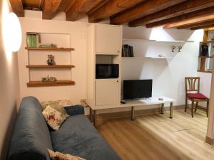 ein Wohnzimmer mit einem Sofa und einem TV in der Unterkunft Ninette Home in Venedig