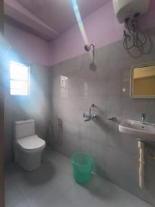 a bathroom with a white toilet and a sink at Hunsi Homestay in Sohrārim