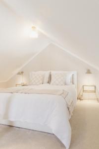 a white bedroom with a bed with white sheets and pillows at Ferienwohnung Weidenbach in Weidenbach