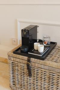 a table with a coffee maker and cups on it at Ferienwohnung Weidenbach in Weidenbach