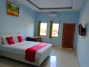 a bedroom with a bed and two windows and a television at Hotel Benson in Cikembulan