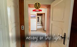 a hallway with a door and a sign moving in the light at Magnificent SUNSTONE HOUSE, private parking, BBQ area, kids toys, near Como lake I Villa dei Leoni in Morbio Inferiore