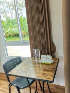 una mesa de madera, una silla y una ventana en My Heaven Resort en Trang