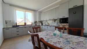a kitchen with a table and some chairs and a table and a tableablish at Casa Elisabeta in Bilca