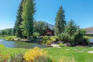 einen Garten mit einem Teich und Bäumen sowie ein Haus in der Unterkunft Bridgepoint Condo 08 in Ketchum