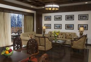 グルマルグにあるThe Khyber Himalayan Resort & Spaのリビングルーム(ソファ、テーブル、椅子付)