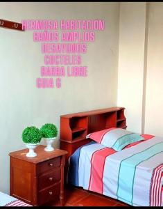 a bedroom with a bed and a sign on the wall at Garrison Alojamiento , selva y Turismo y Comida in Tingo María