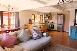 a living room with a couch and a kitchen at Mountain View Cottage in Dullstroom