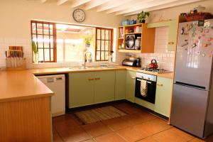 a kitchen with green cabinets and a white refrigerator at Mountain View Cottage in Dullstroom