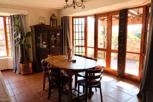 a dining room with a wooden table and chairs at Mountain View Cottage in Dullstroom