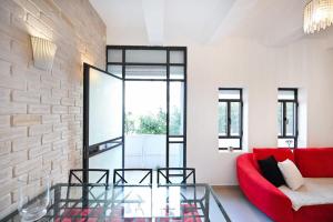 uma sala de estar com um sofá vermelho e uma mesa de vidro em Nice 2BR near Gordon Beach by HolyGuest em Tel Aviv