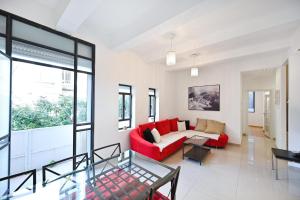 uma sala de estar com um sofá vermelho e uma mesa de vidro em Nice 2BR near Gordon Beach by HolyGuest em Tel Aviv