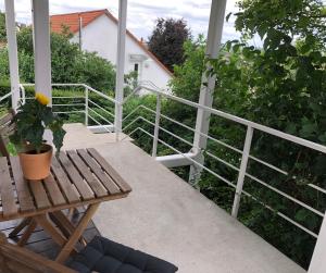 un porche con un banco de madera y una maceta en ☆ Zentrales Appartement mit traumhaftem Panorama ☆, en Winnenden