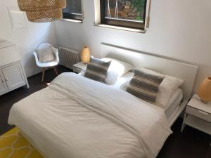 Un dormitorio con una cama blanca con almohadas y una ventana en ☆ Zentrales Appartement mit traumhaftem Panorama ☆, en Winnenden