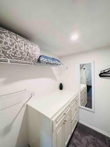 a white room with a shelf and a mirror at 2 Bedrooms Private Basement Suite Close to Winsport & Downtown in Calgary