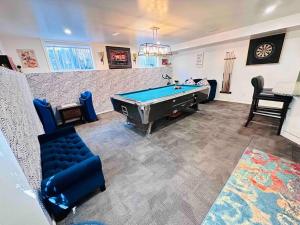 a living room with a pool table and chairs at 2 Bedrooms Private Basement Suite Close to Winsport & Downtown in Calgary