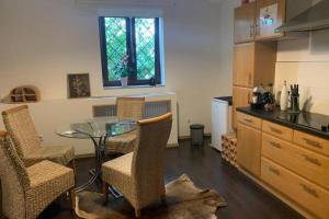 eine Küche mit einem Glastisch und Stühlen im Zimmer in der Unterkunft Gartenwohnung 5 min. zur Stadt in Hagenau