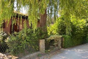 ein Haus mit einem Zaun und einem Baum in der Unterkunft Gartenwohnung 5 min. zur Stadt in Hagenau