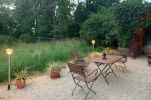 einen Holztisch und Stühle im Garten in der Unterkunft Gartenwohnung 5 min. zur Stadt in Hagenau