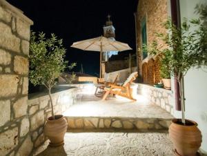 a patio at night with an umbrella and a chair at LUCA'S HOUSES in Halki