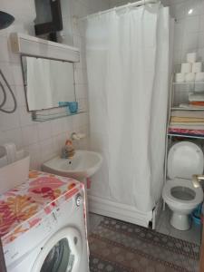 een wasmachine in een badkamer met een toilet en een wastafel bij Timo Bokelski in Donji Stoliv