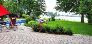un patio con tavolo, sedie e fiori di Villa Delrose Waterfront a Montréal