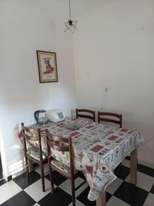 een eettafel en stoelen met een tafelkleed erop bij Timo Bokelski in Donji Stoliv