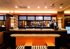 a bar in a restaurant with an orange counter at APA Hotel Sapporo Odori Ekimae Nishi in Sapporo