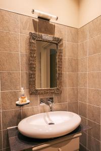 uma casa de banho com um lavatório e um espelho na parede em Boutique Hotel Casa Grimaldi em Matelica