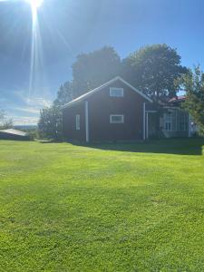 Una casa en un campo con el sol detrás. en Villa Gasabäck, en Söråker