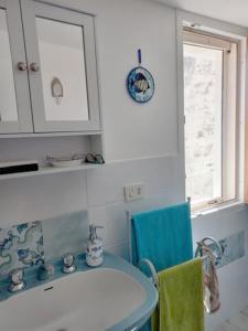 La salle de bains est pourvue d'un lavabo et d'une chaise bleue. dans l'établissement Casa Cecilia, 