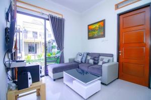 ein Wohnzimmer mit Sofa und Fernseher in der Unterkunft Harsari Syariah with Karaoke and Balcony in Batu