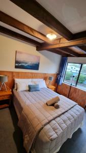 ein Schlafzimmer mit einem großen Bett in einem Zimmer mit Fenstern in der Unterkunft Adventure Lodge and Motels and Tongariro Crossing Track Transport in National Park