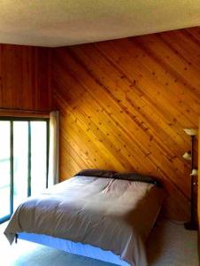 a bedroom with a bed in a wooden wall at River Retreat+ Indoor Pool & Hot Tub on 3.5 Acres in Lewiston