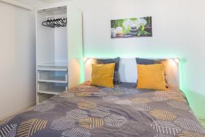 een slaapkamer met een bed met gele kussens bij Beautiful renovated studio with view- Old Hyères in Hyères