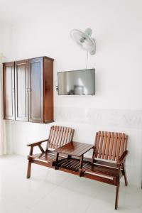 two wooden chairs and a table in a room at MOTEL CASON in Chau Doc