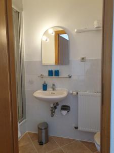 La salle de bains est pourvue d'un lavabo et d'un miroir. dans l'établissement Kottmarschenke - Gästezimmer und Ferienwohnung am Kottmar, à Kottmar