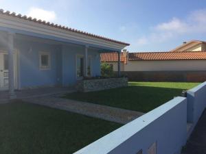 ein Haus mit einem Garten mit grünem Gras in der Unterkunft Maison proche de la mer in Murtosa