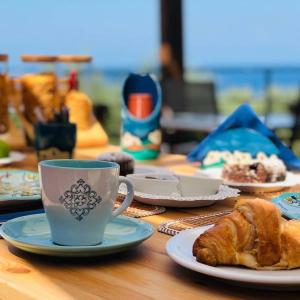 una mesa con una taza de café y un plato de pan en Dimora Acqua del Fico, en Castellabate