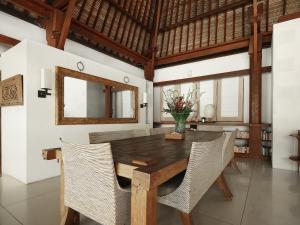 a dining room with a wooden table and chairs at Casa Evaliza in Seminyak