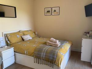 a bedroom with a bed with a yellow comforter at Private Entry Double bedroom with beautiful views! in Solihull