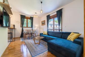 a living room with a blue couch and a table at FOREST GREEN in Kolašin