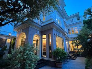 duży biały dom z mnóstwem okien w obiekcie Luxury Garden Villa with premium spa 4 bedrooms Ciputra w mieście Hanoi