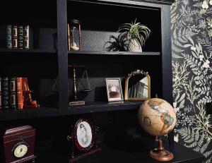 a shelf with a globe and a clock on a table at Mr. McGregor’s Garden in Salem