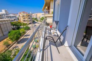 a balcony with two chairs and a view of a street at Gianni's comfort by homebrain in Alexandroupoli