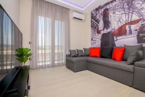 a living room with a gray couch and a tv at GIANNI'S COMFORT CITY APARTMENT in Alexandroupoli