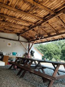 a large wooden picnic table in a room with a ceiling at Glamping Wild Nature Bałtów in Bałtów