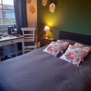 a bedroom with a bed with two pillows on it at B&B Waardevol, Julianastraat 2L in Waarde